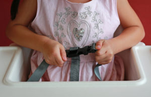 Close-up,Child,Sitting,On,High,Chair,Seat,With,Fastening,Safety
